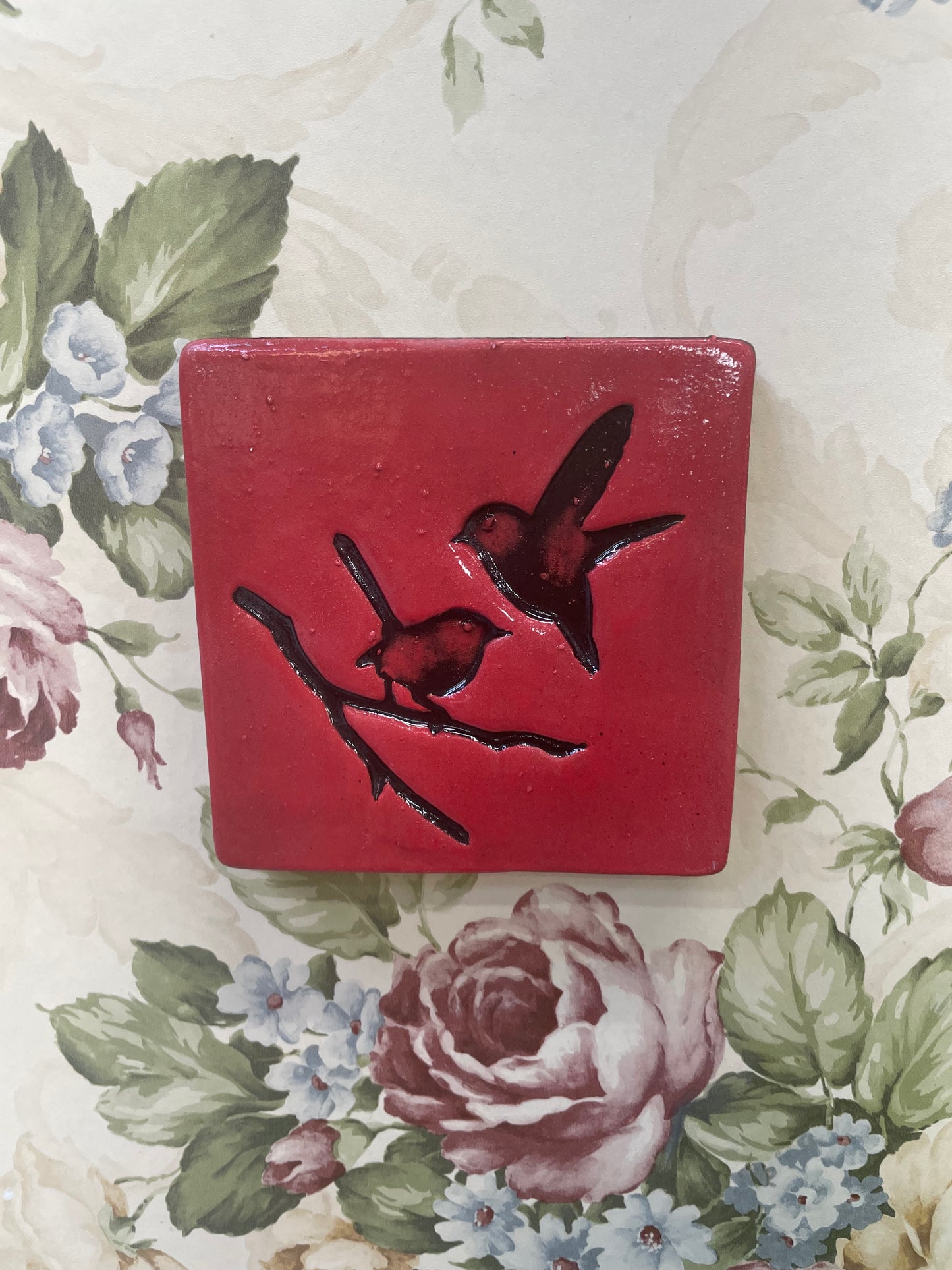 Square tile, red with black birds.